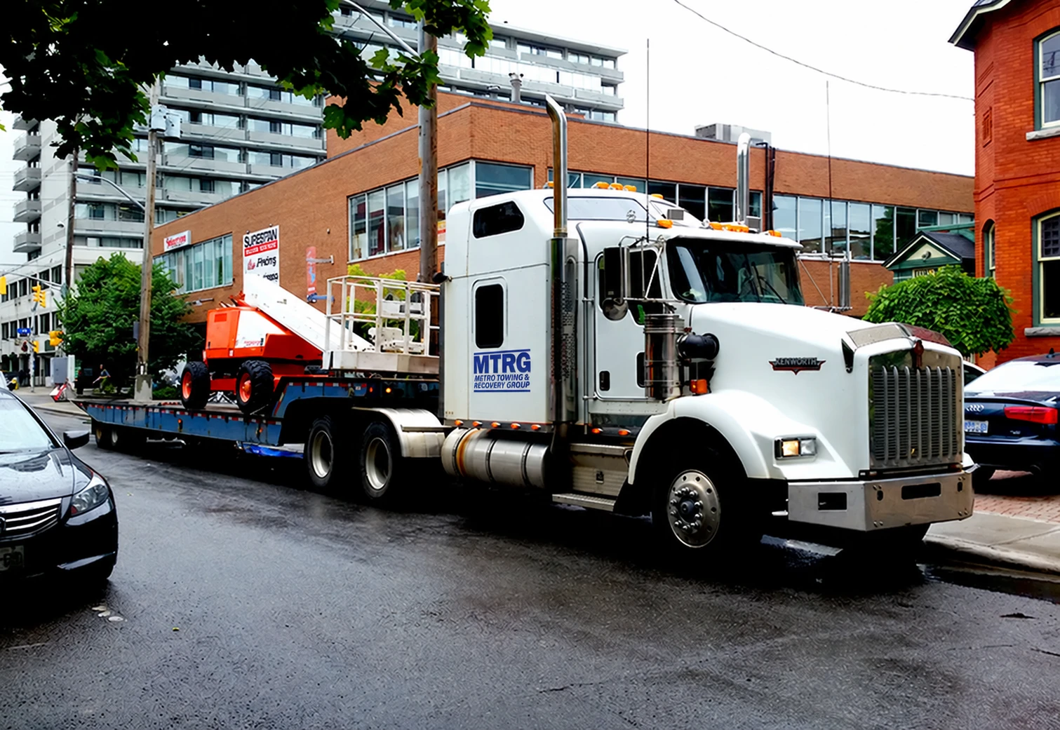 MTRG heavy truck transporting construction equipment through the city