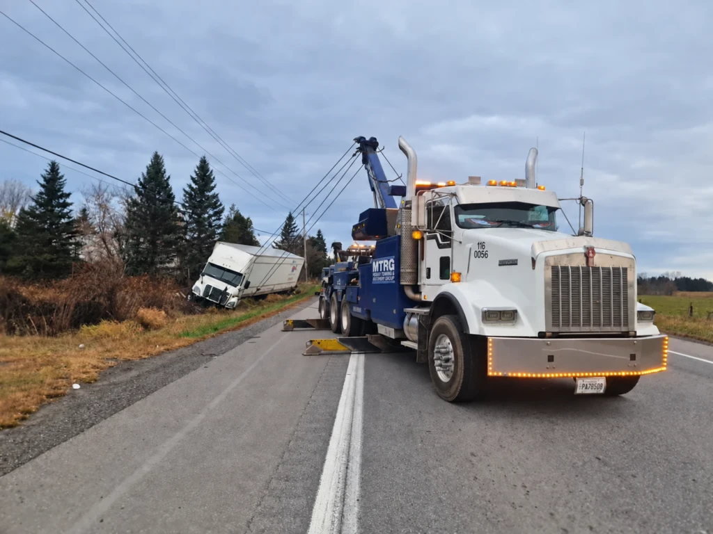 MTRG heavy wrecker recovering a truck from a roadside ditch
